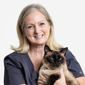 Debs holding a brown cat and smiling at the camera
